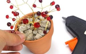 اضافه کردن سنگریزه به گلدان برای ساختن کاردستی